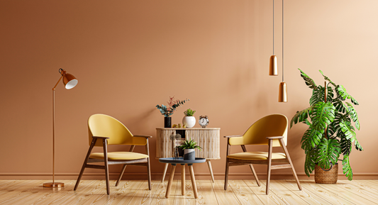 Modern living room with yellow chairs, wooden table, monstera plant, pendant lights, and beige walls for a cozy, stylish vibe.