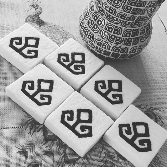 Handmade Turkish felted soap bars with traditional eli belinde motif representing fertility, displayed with a vase & embroidered tablecloth