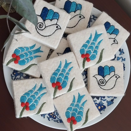 Handmade Turkish felted soap bars with Ottoman tulip and hamsa patterns, displayed on a decorative plate.