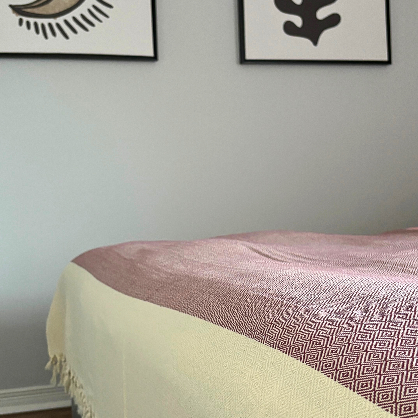 SULTAN Bedspread in burgundy with geometric patterns and hand-knotted fringes, neatly draped over a bed, showcasing its soft texture and premium Turkish cotton fabric